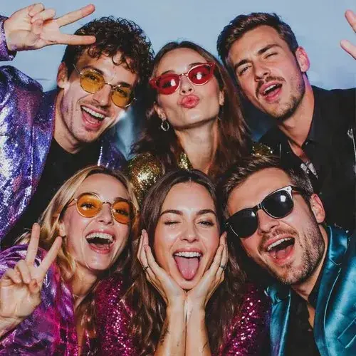 Jautri ballītes viesi ar saulesbrillēm foto kastes kadrā